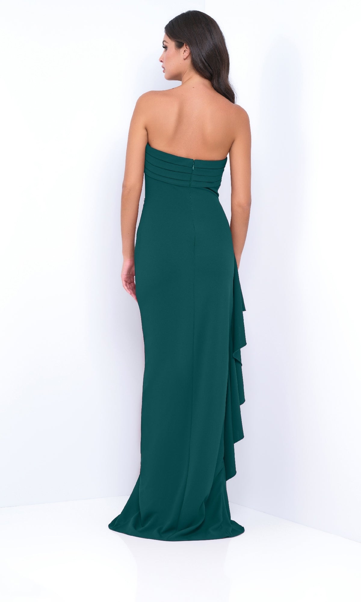 A woman stands against a white background wearing the Velvi Marie Strapless Long Ruffle Prom Dress in dark green, featuring a fitted bodice and cascading ruffle detail on the back.